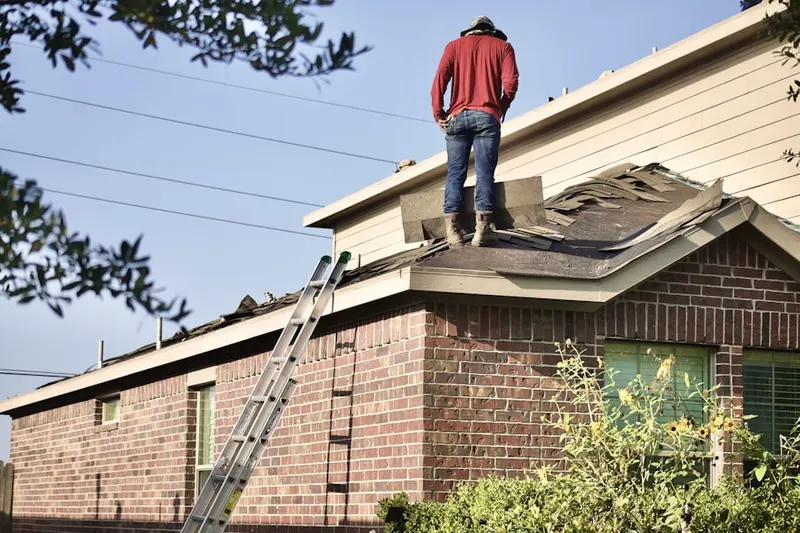 Professional roofer working on a residential roof in Oneida